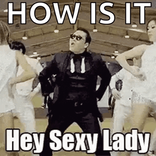 a man in a suit and tie is dancing in front of a group of people and says `` how is it hey sexy lady '' .