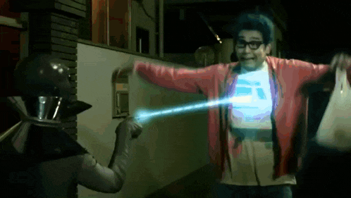 a man in a red cardigan is being attacked by a robot