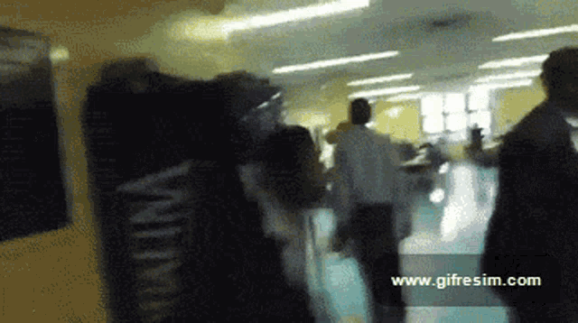 a blurry photo of people walking with the website www.gifresim.com visible