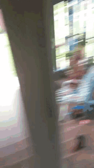 a blurry picture of a person standing in front of a computer screen