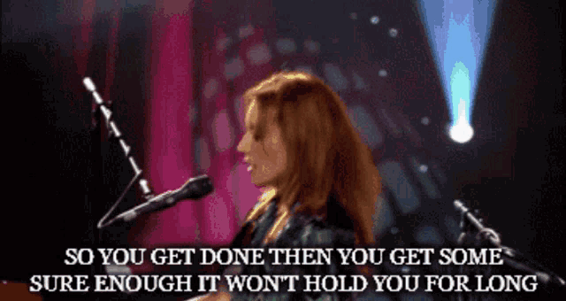 a woman singing into a microphone with the words so you get done then you get some sure enough it wont hold you for long