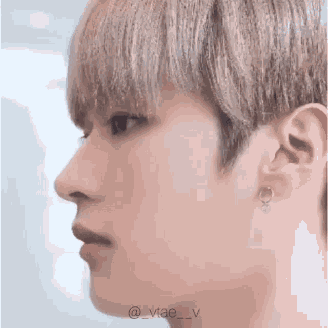 a close up of a person 's face with earrings on