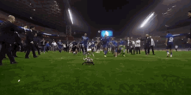 a group of soccer players laying on the field holding a trophy
