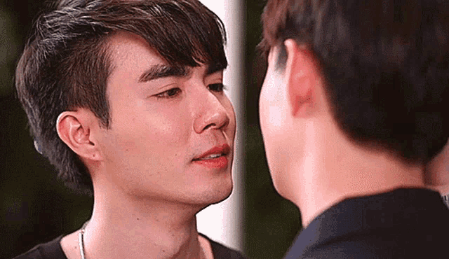 two men are touching each other 's faces .