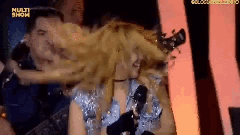 a woman is singing into a microphone with the words multi show on the bottom right