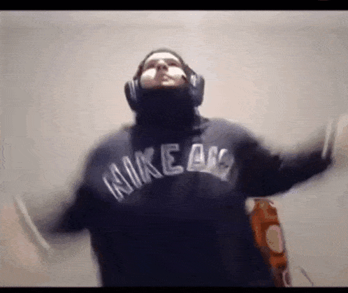 a man wearing headphones and a nike hoodie is dancing .