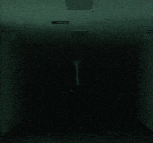 a man in a suit is standing in a dark hallway .