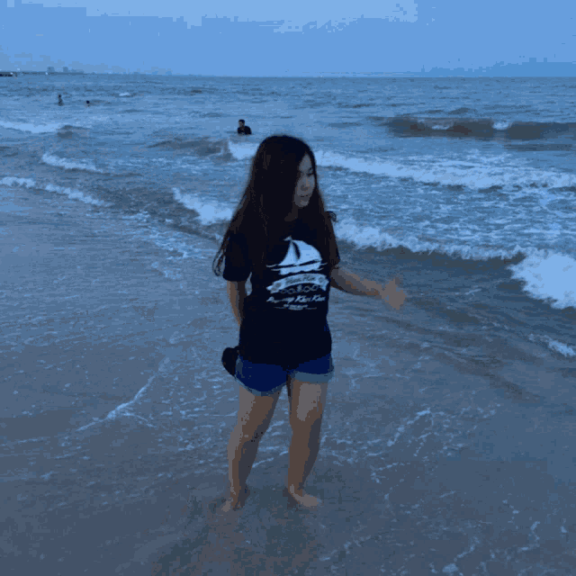 a woman standing on a beach wearing a t-shirt that says hua hin