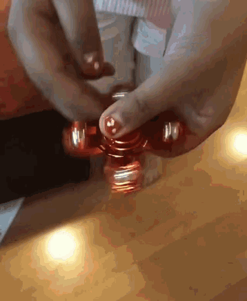 a person is spinning a red fidget spinner in their hand