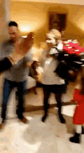 a group of people are dancing in a living room with a dog .