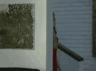 a woman in a red dress is walking down a staircase