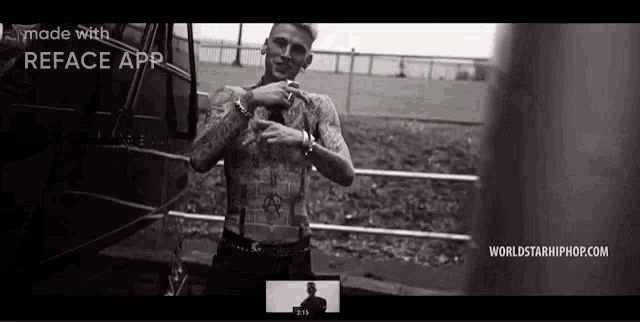 a man with a lot of tattoos on his body is standing in front of a bus .