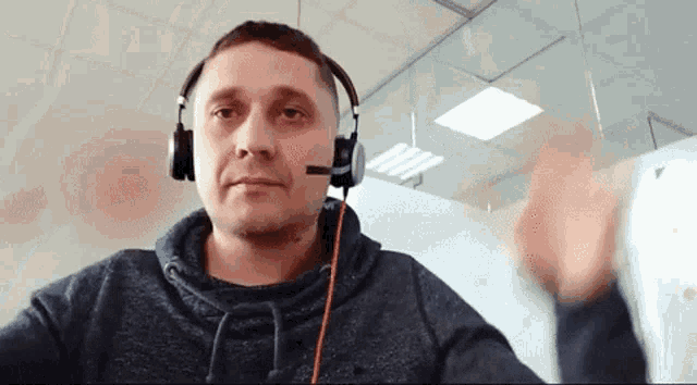 a man wearing headphones with a microphone on his head is talking on a video call .