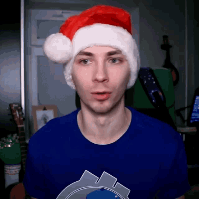 a man wearing a santa hat and a blue t-shirt