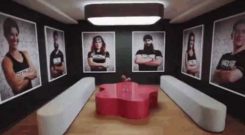 a room with a red table and a bunch of pictures on the wall .