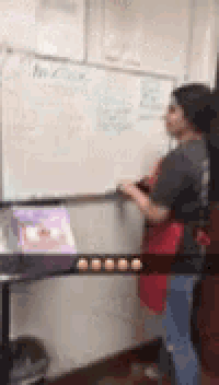 a woman is standing in front of a whiteboard .