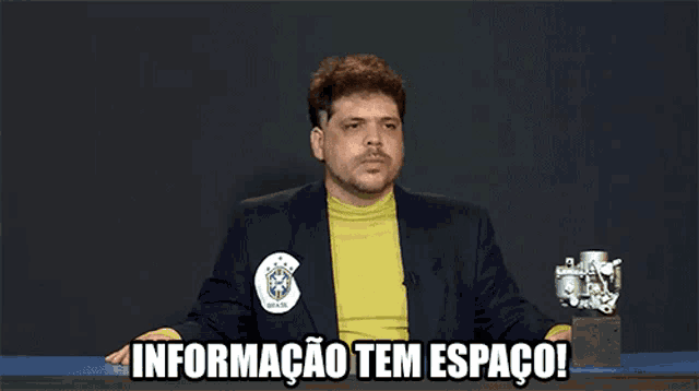 a man sitting at a table with the words informacao tem espaco written below him