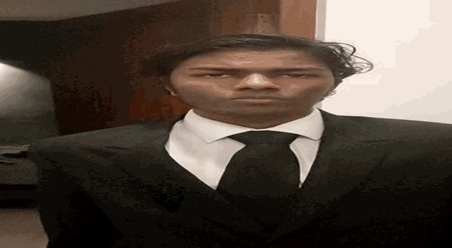 a man in a suit and tie is looking down at the camera