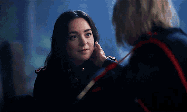 a woman touching another woman 's face with her hand