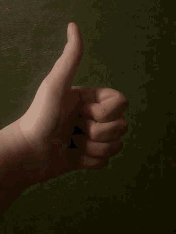 a blurry picture of a person 's hand against a green background