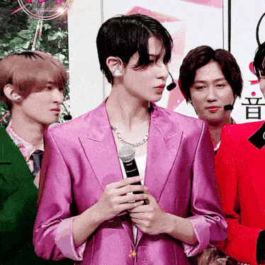 a man in a purple jacket holds a microphone