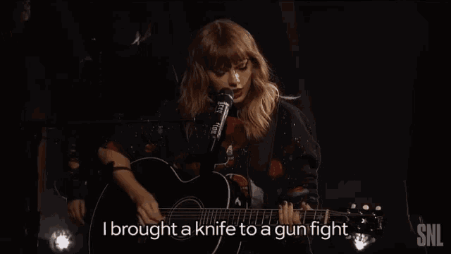 a woman is singing into a microphone while holding a guitar and the words i brought a knife to a gun fight