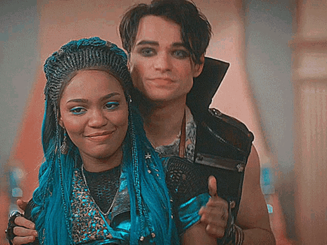a man and a woman are posing for a picture and the woman has blue hair .