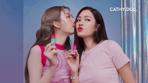 two women are kissing each other with the words cathy doll behind them