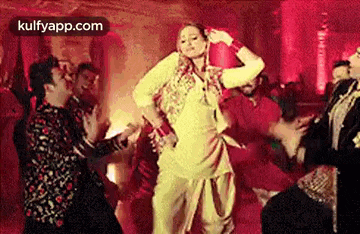 a woman is dancing in front of a crowd of people .