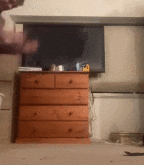 a wooden dresser is in front of a television