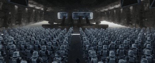 a man is standing in front of a large group of stormtroopers