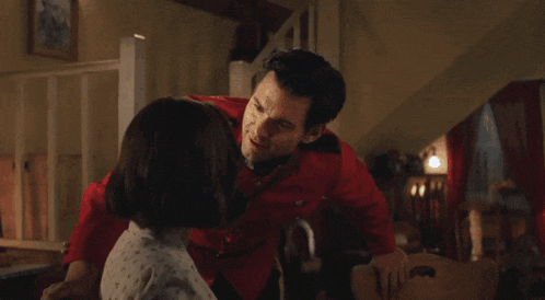 a man in a red uniform is kissing a woman on the cheek