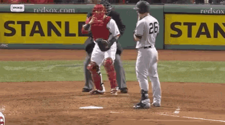 a baseball player with the number 26 on his jersey stands on the base
