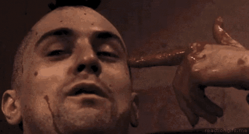 a close up of a man 's face with blood on it and a hand pointing at it .