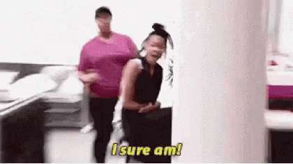 a woman is standing next to another woman in a room and says `` i sure am ! ''