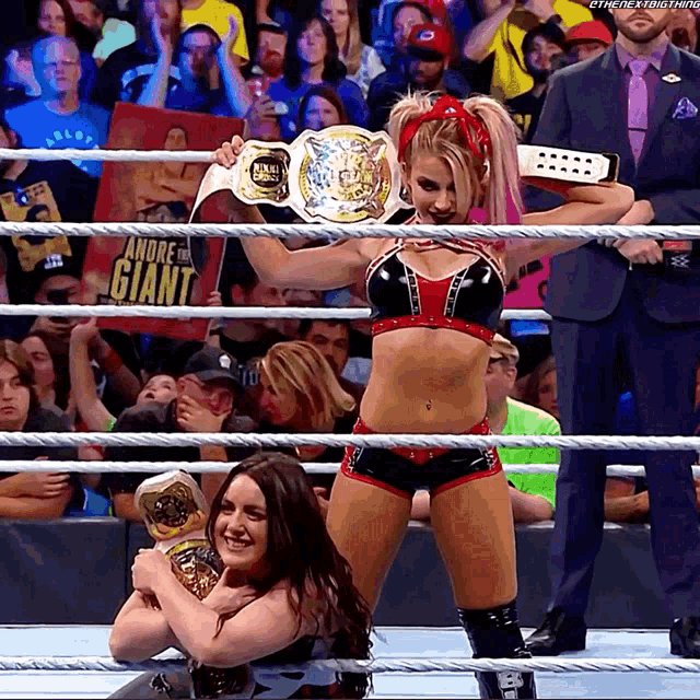 a woman in a wrestling ring holds a belt that says andrea the giant
