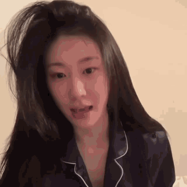 a woman with long hair wearing a blue pajama shirt
