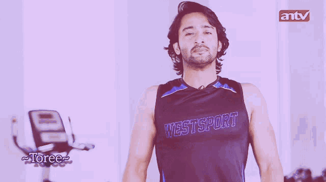a man wearing a westsport tank top blowing a kiss