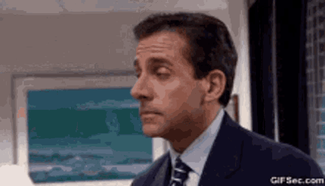 a man in a suit and tie is looking to the side .