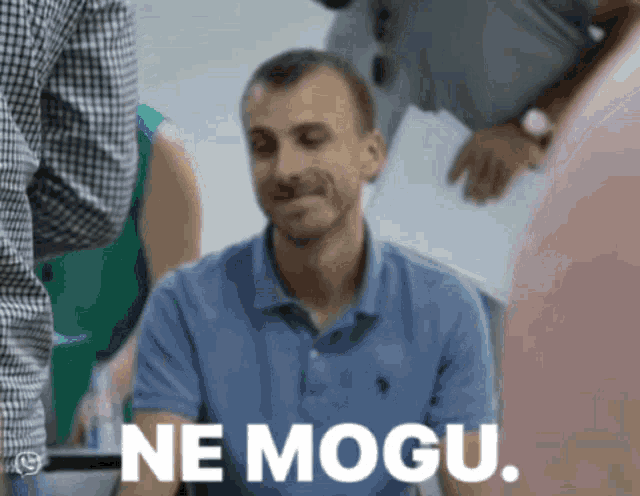 a man in a blue polo shirt with the words ne mogu on the bottom