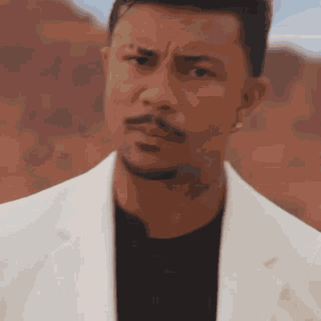 a man with a beard is wearing a white jacket