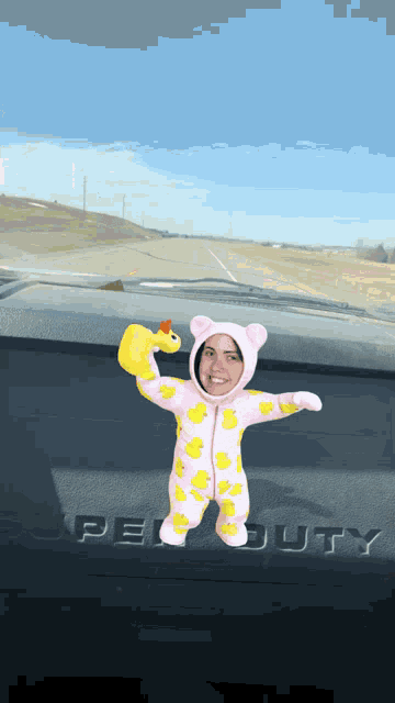 a baby in a duck suit is holding a rubber duck