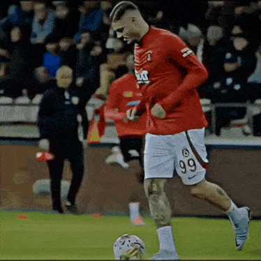 a soccer player with the number 99 on his shorts is kicking a ball