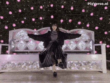 a woman sitting on a bench with her arms outstretched in front of a wall of pink and white lights