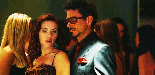 a man in a suit is standing next to a woman in a dress .