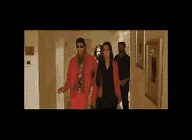 a group of people are walking down a hallway in a room .