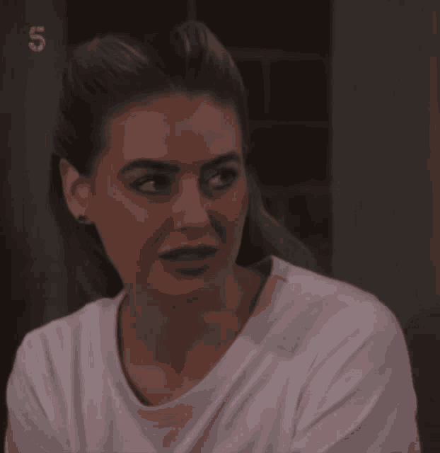 a woman wearing a white shirt with the number 5 on the bottom left