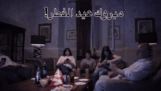 a group of people are sitting in a living room with arabic writing on the walls