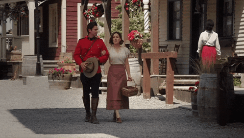 a man in a red uniform walking with a woman