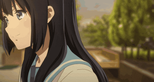 a girl with long black hair and blue eyes stands in a park